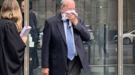 Paedophile priest Rex Francis Elmer tried to hide his face after pleading guilty in the County Court in Melbourne on Monday.