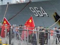 Members of the public hold Chinese flags on the wharf as the three ships arrive in Sydney. Picture: Bianca De Marchi/AAP